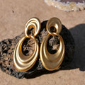 Pair of quicksand gold copper earrings showing a U-shaped design with a double circle detail.