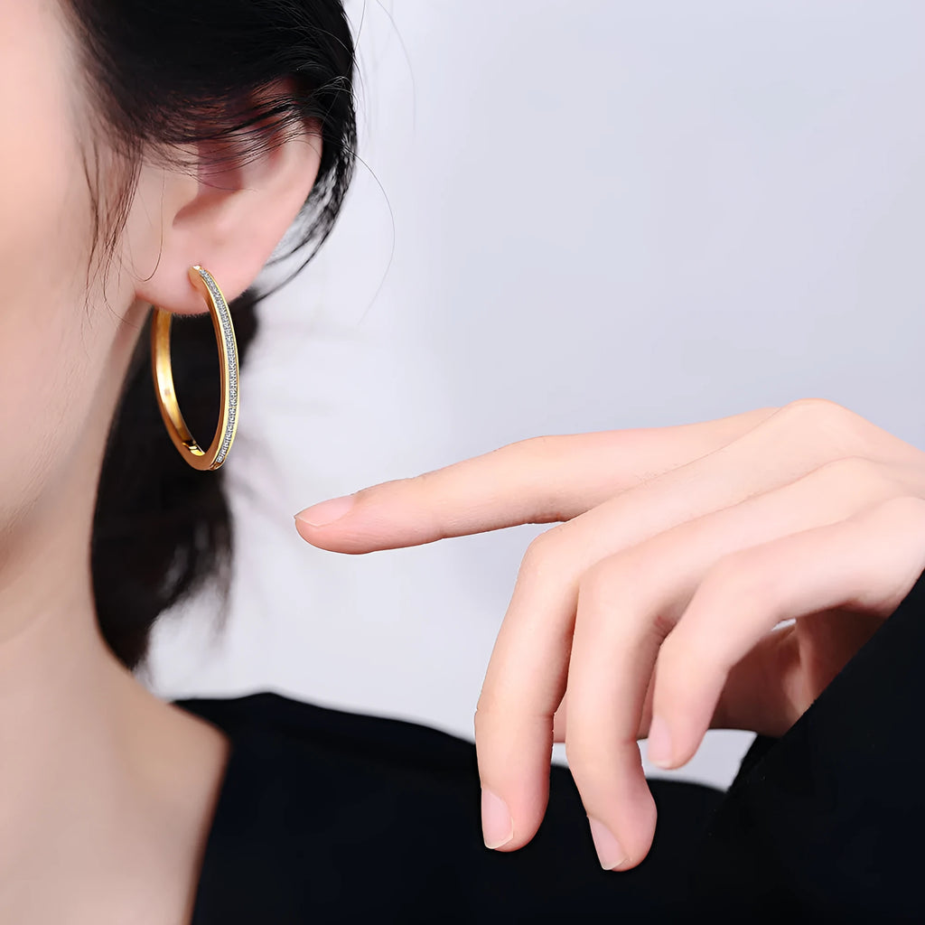 Gold-toned copper clip-on earring with round geometric shape and inlaid zircon stone