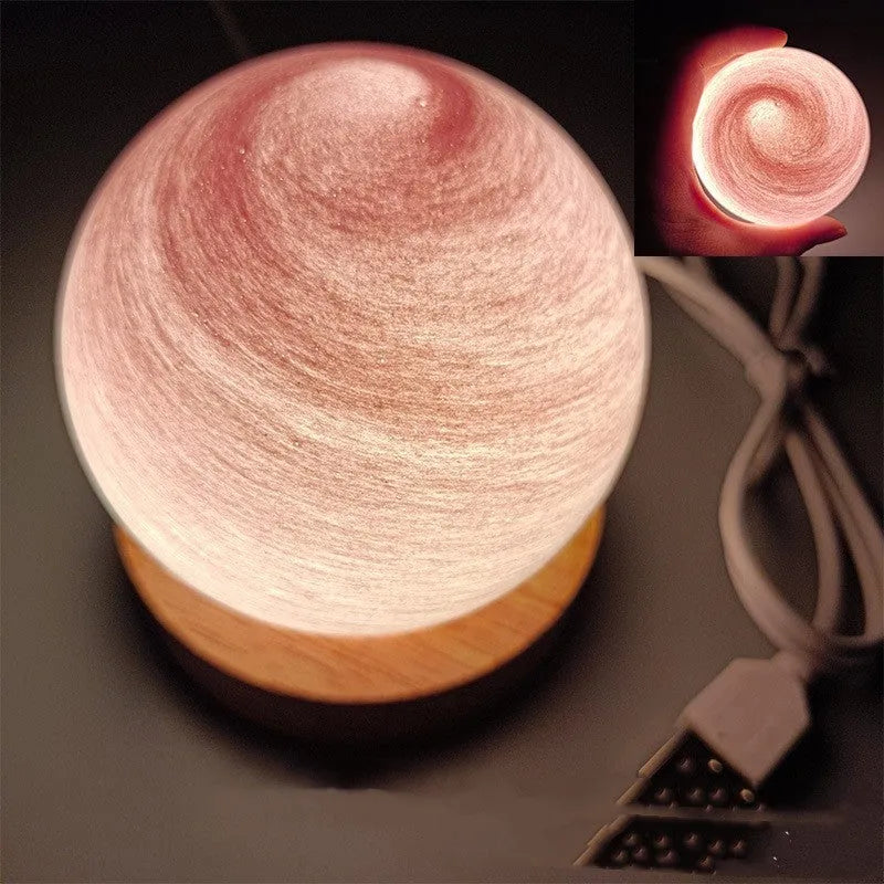Planet night light with spherical design on base, USB cable connected, showing adjustable three-colour lighting