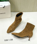 Black pointed toe women's ankle boots with a high stiletto heel on a rubber sole.