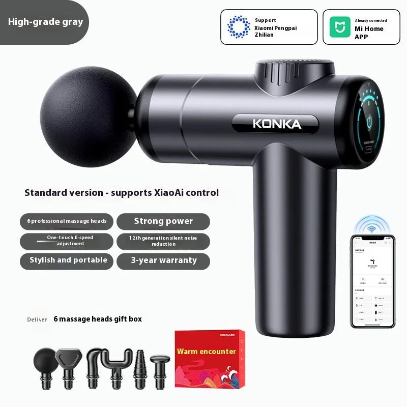 Konka professional electric mini massage gun in grey colour with multiple massage head attachments on a table.
