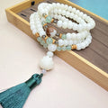 White jade bodhi 108-bead mala bracelet showing round beads in one of three pattern styles.