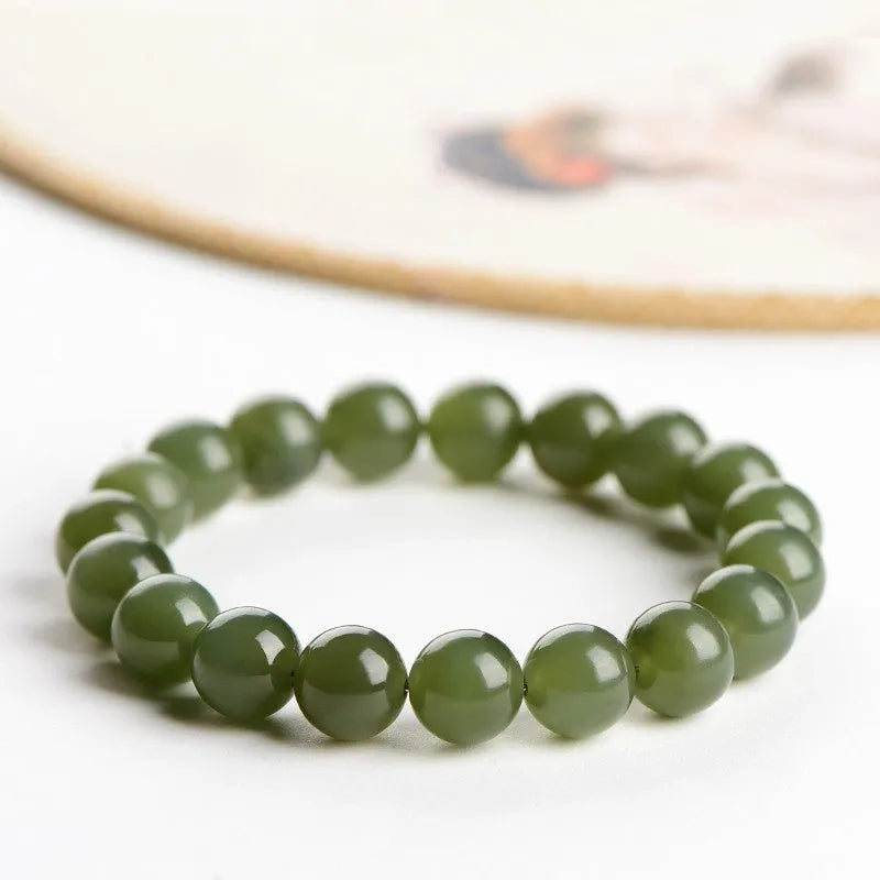 Polished Hetian jade bead bracelet in clear ice-like colours on a white background.