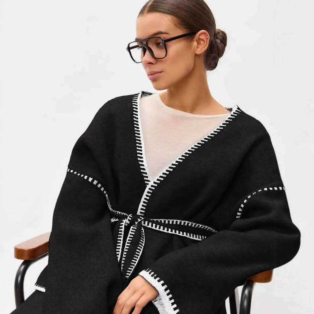 Loose fit camel coloured knitted cardigan sweater with long sleeves laid flat.