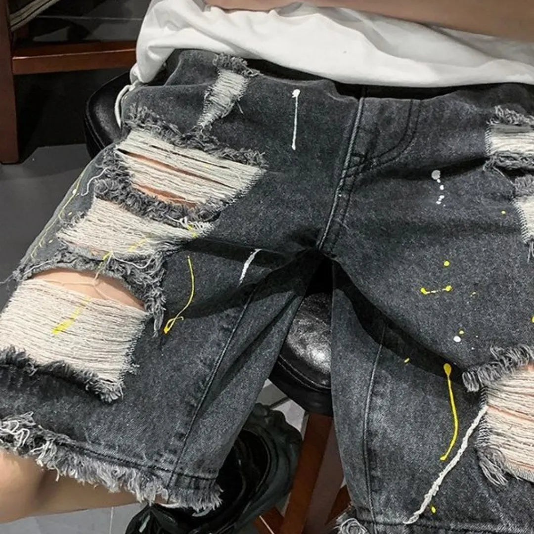 Men's loose fit light blue denim shorts with a water washed finish and hole detailing on a solid background.