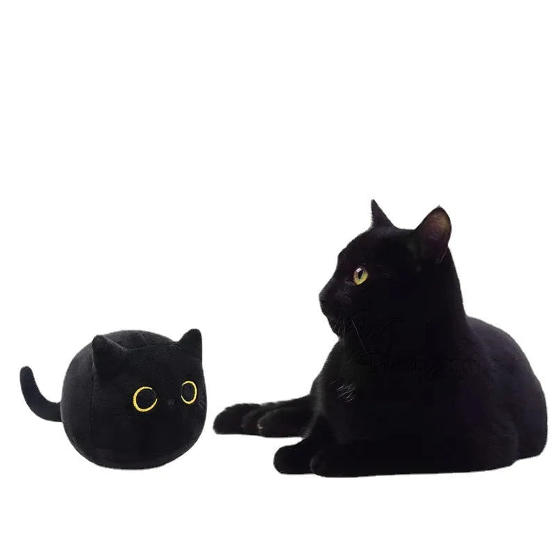 Black fluffy cat plush toy with printed face, sitting upright as a soft cushion.