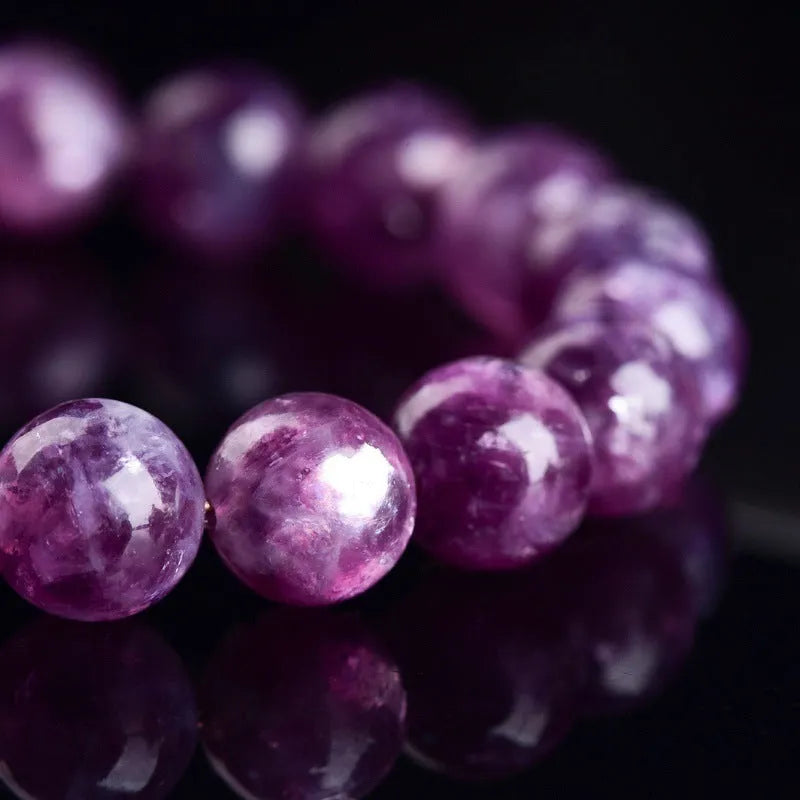 Purple polished crystal beaded bracelet with geometric beads on a white background.