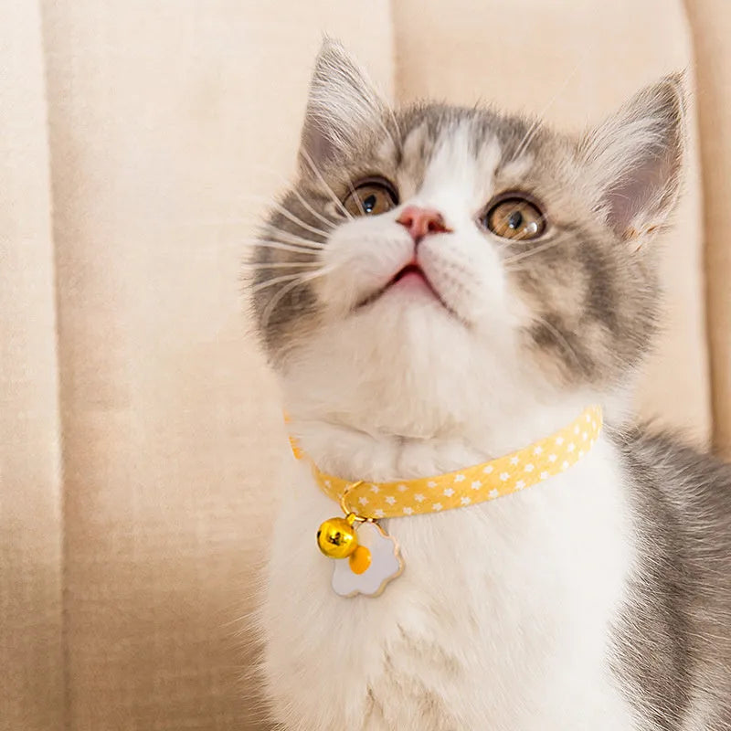 Adjustable green cat collar with a metal bell and a matching bow tie for small pets.