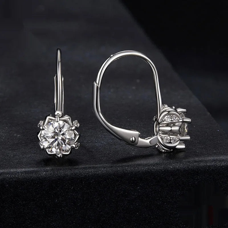 A pair of sterling silver flower bud design ear clips with white gold plating and moissanite stones.