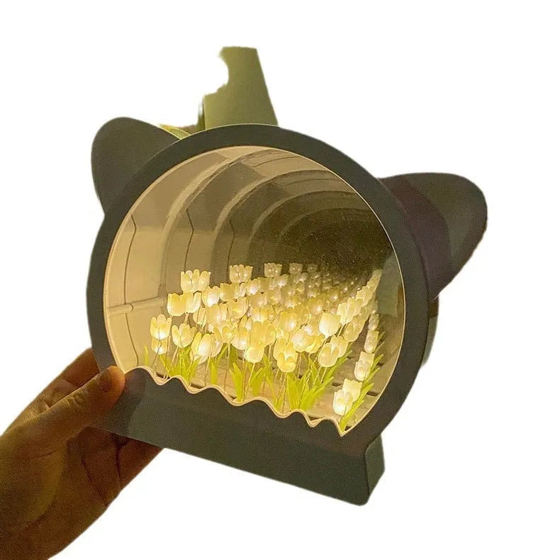 Assembled DIY cat head-shaped night lamp with pink artificial tulips on a white background.
