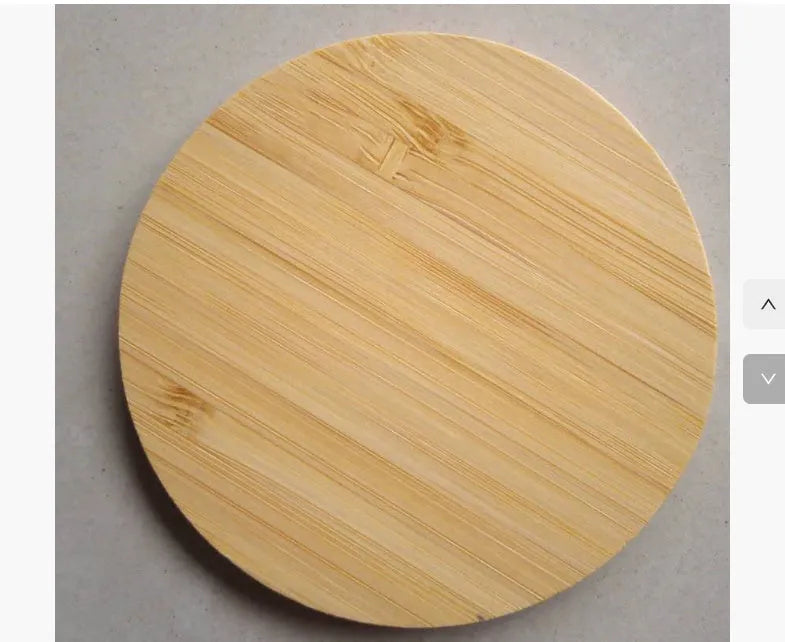 Square wooden bamboo 5W Qi wireless charging pad on a desk next to a smartphone.