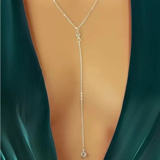 Female gold alloy O-ring chain necklace with geometric pendant on a light background