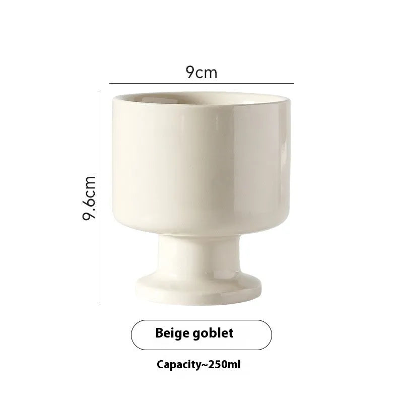 Hand-pinched irregular shaped ceramic mug in a solid colour on a table.