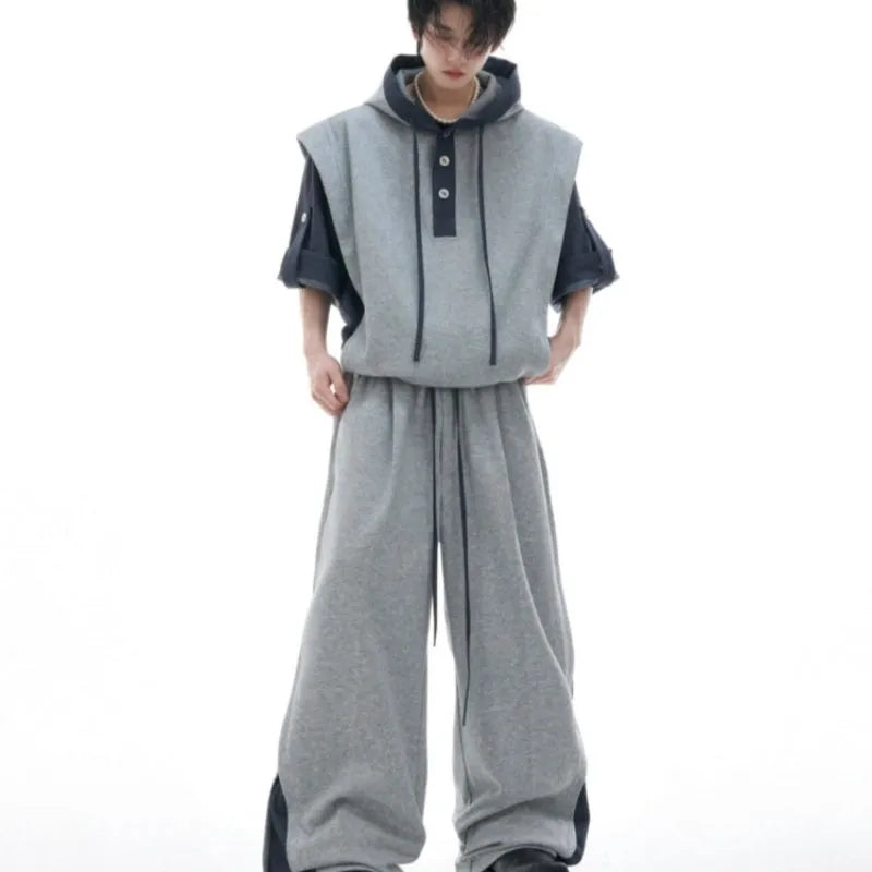 Men's black polyester sports suit with hooded short sleeve jacket and matching trousers laid flat