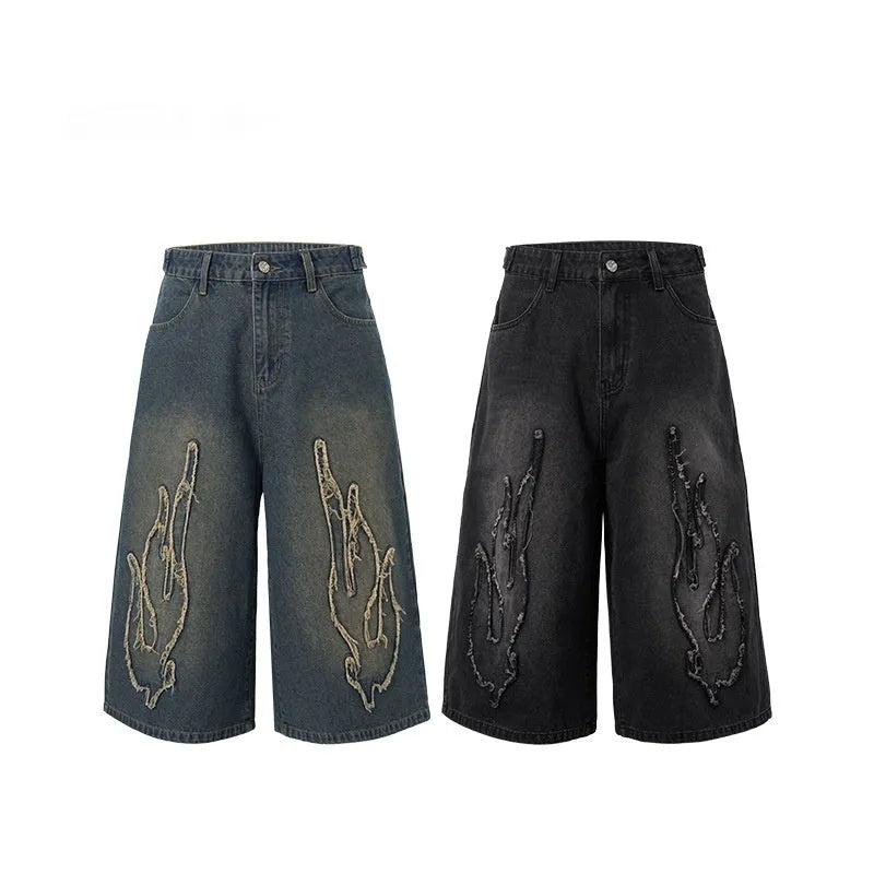 Men's black denim shorts with flame embroidery patches showing straight-leg cropped design