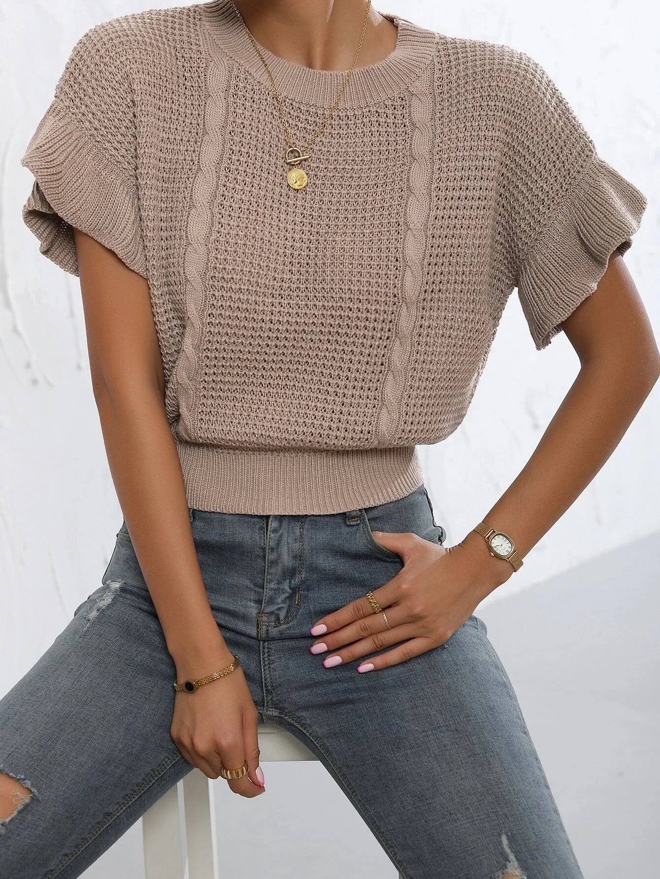White knitted pullover sweater with ruffled short sleeves created from twisted string, shown in a loose fit.