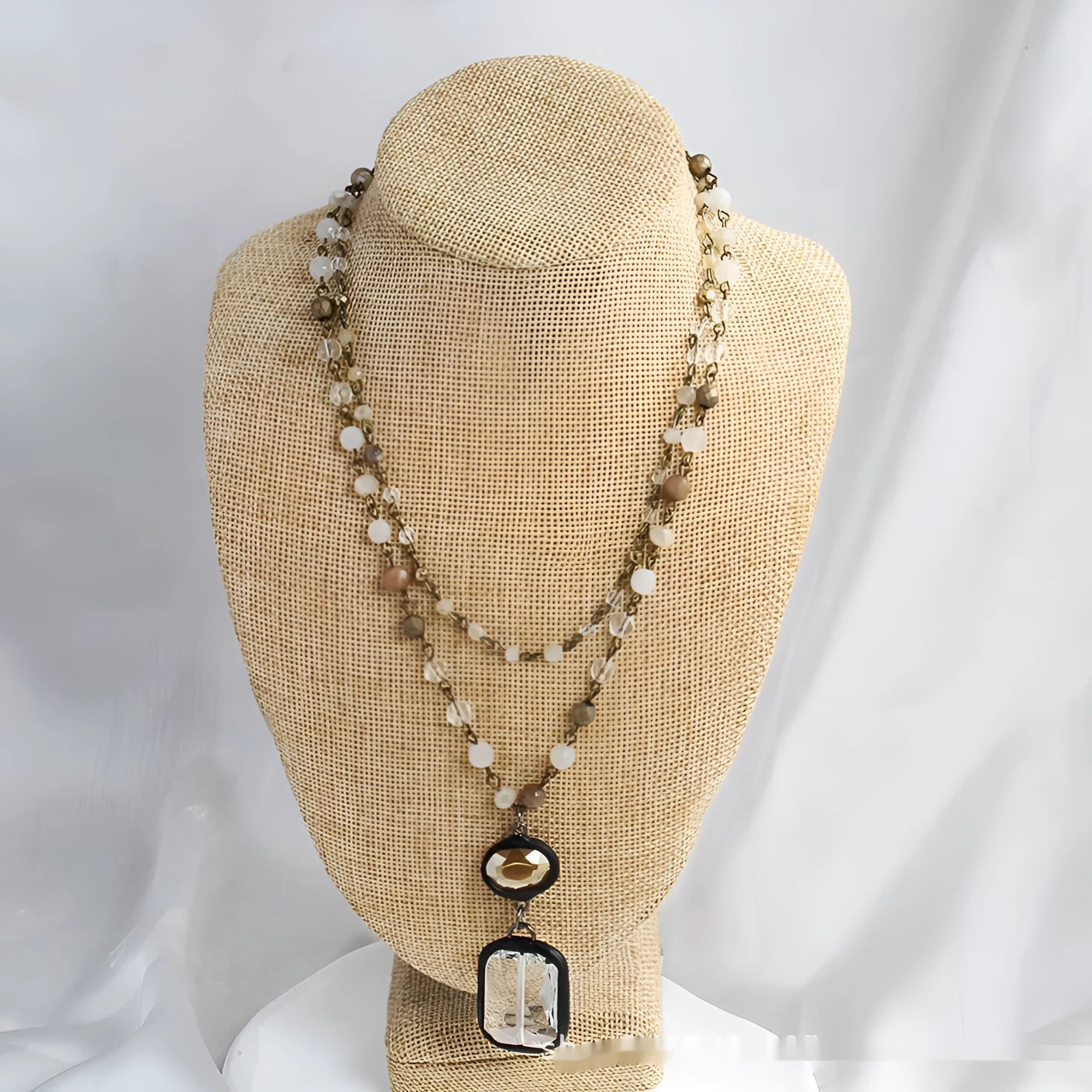 Two-layer tribal necklace with stone and glass pendants on a chain, shown in beige and blue.