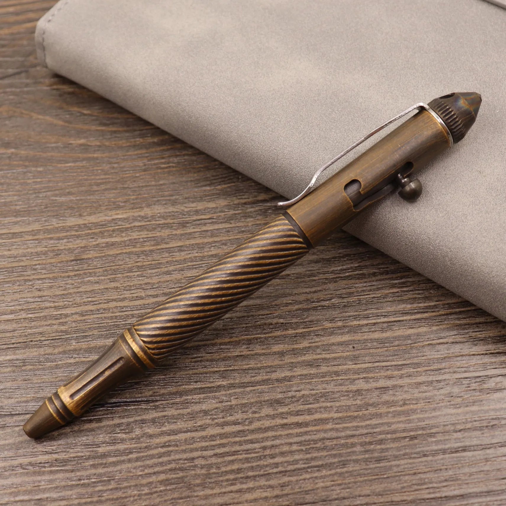 Retro brass tactical pen with cylindrical barrel and six-ring grip, shown with press mechanism extended