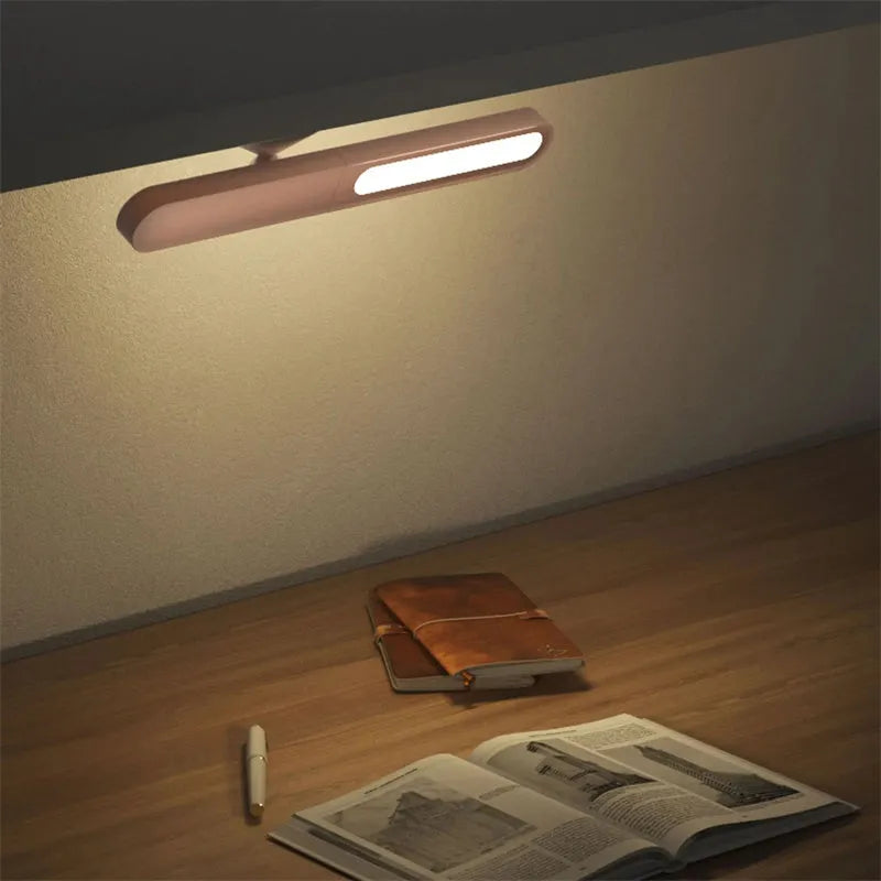 White geometric table lamp with touch switch and USB cable on a wooden desk.