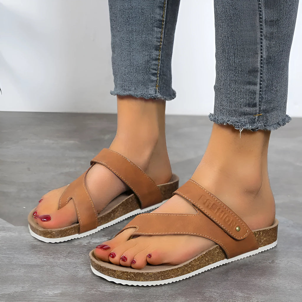 A pair of thick-soled flat toe ring flip-flops in a solid colour on a white background.