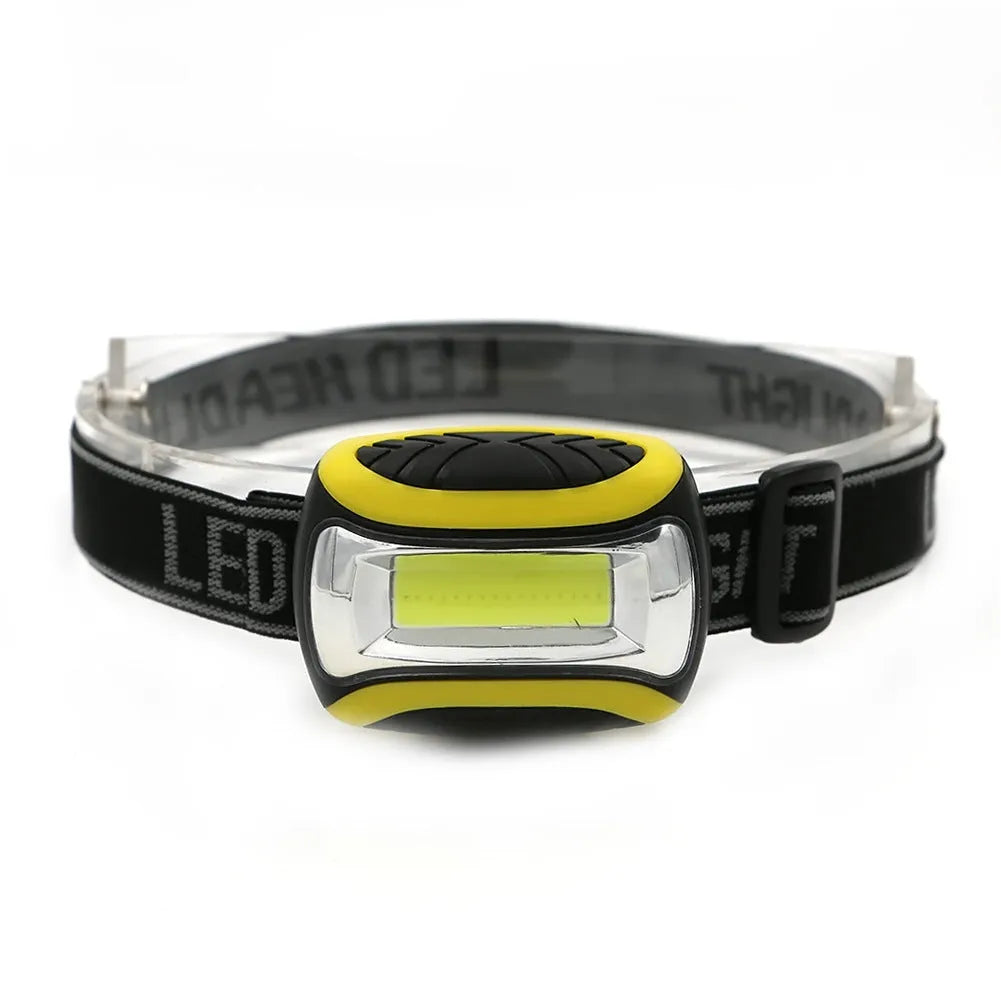 Yellow plastic headlamp with adjustable strap and COB light lens for outdoor use.
