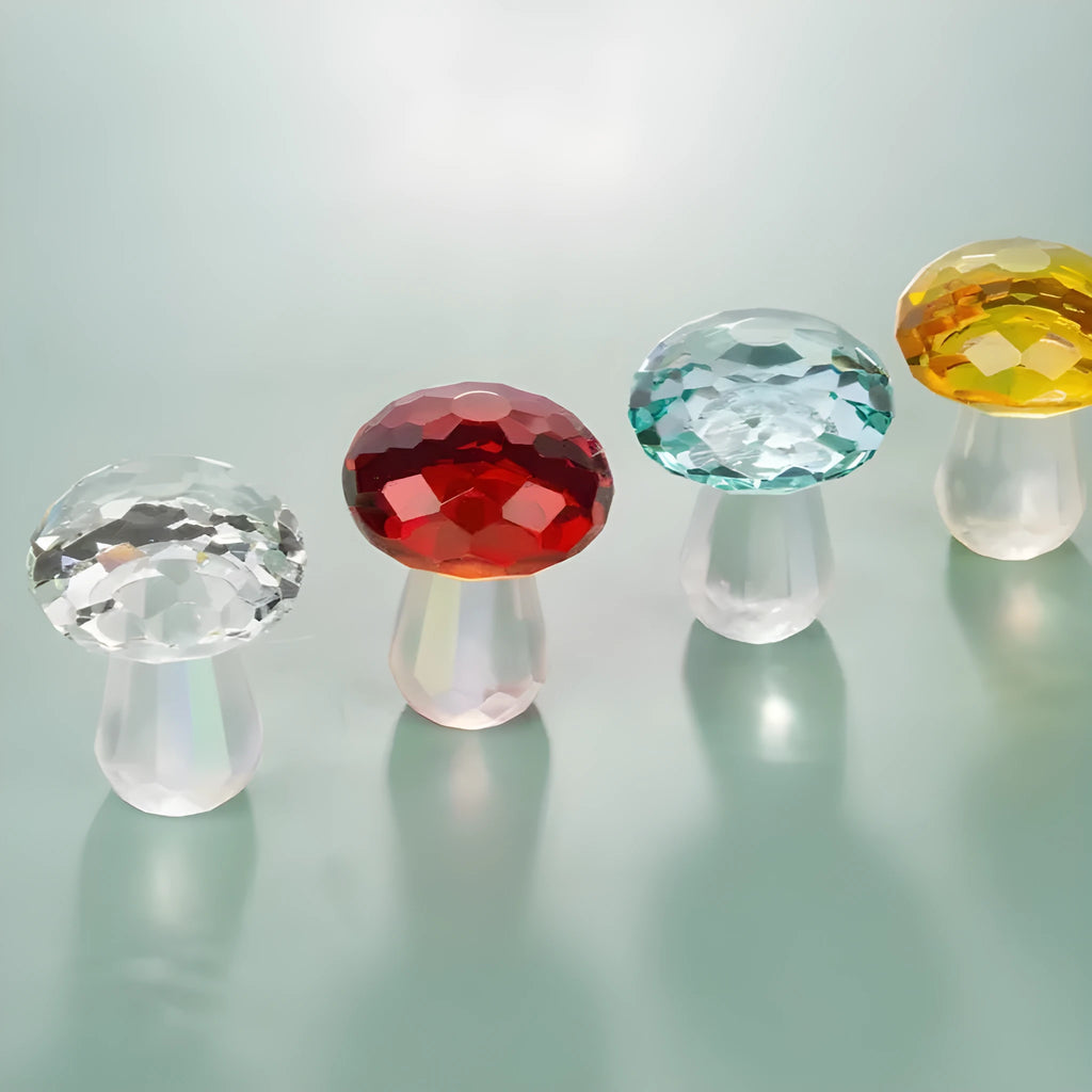 Set of four colourful crystal mushroom decorations in transparent, green, red, and yellow on a white background.