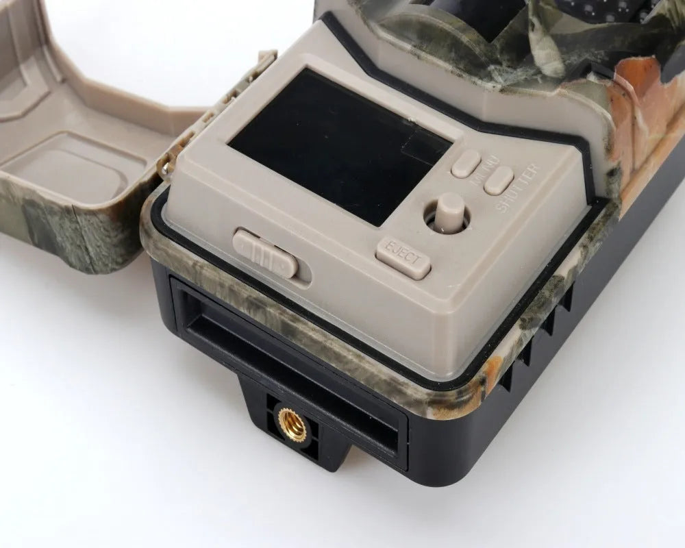 Camouflaged outdoor hunting camera with infrared LEDs, showing compact size for discreet placement.