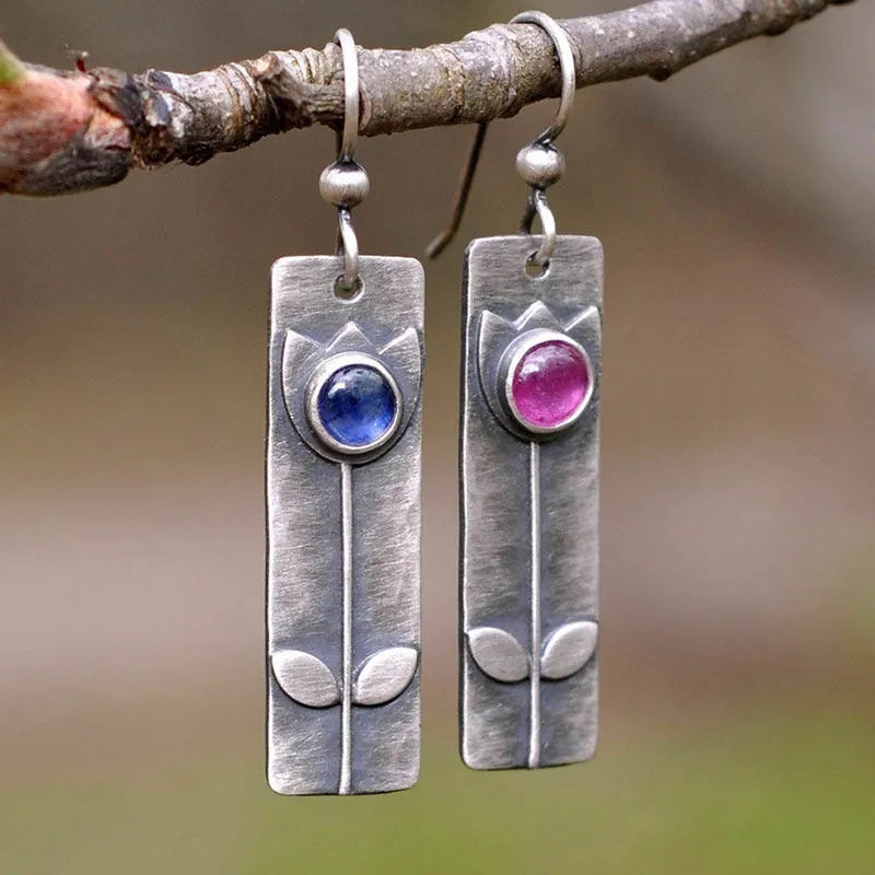 Pair of women's antique finish earrings with red sapphires, geometric shape, and ellipse design on a retro electroplated metal setting.
