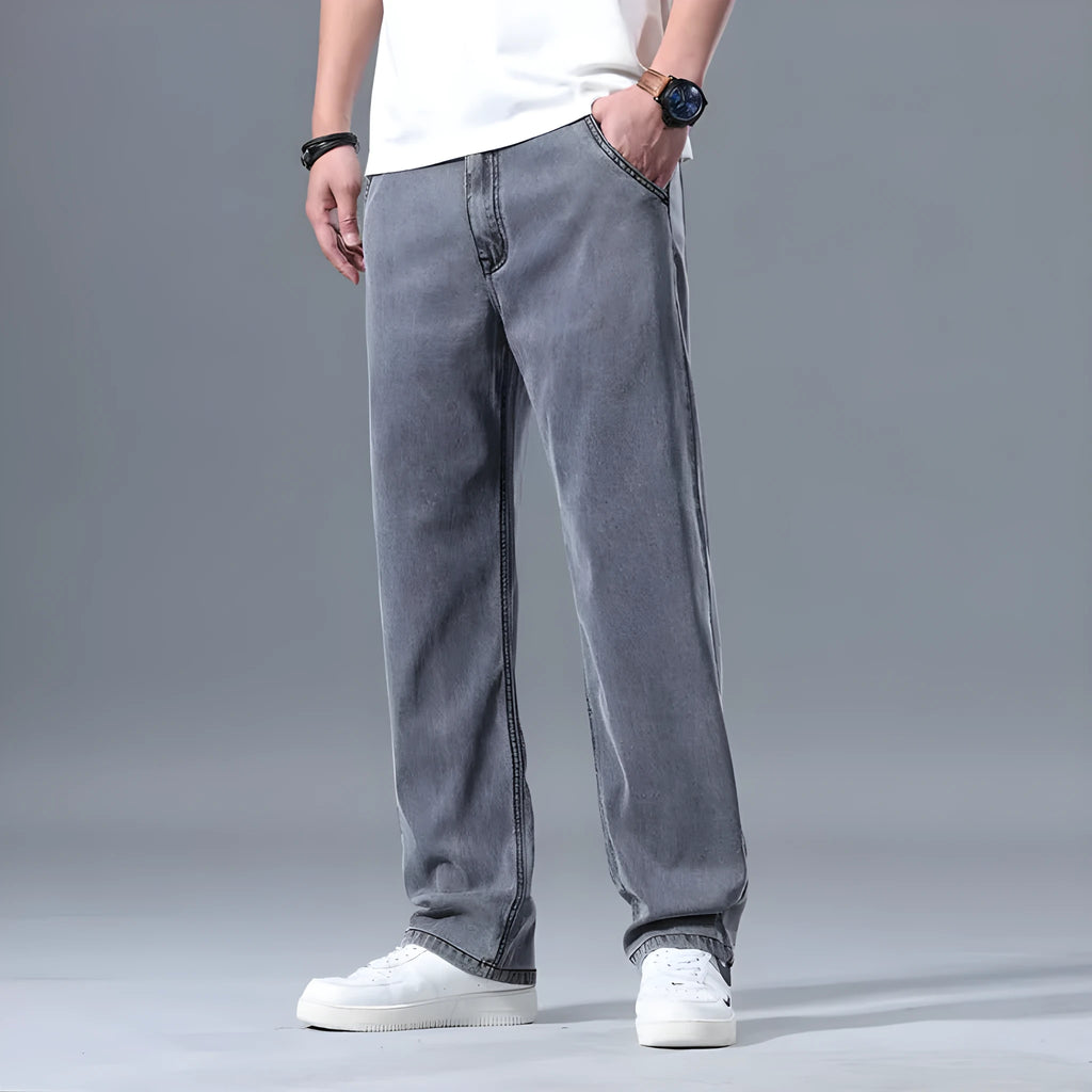 Man wearing light blue loose straight-leg lyocell jeans on a casual background.