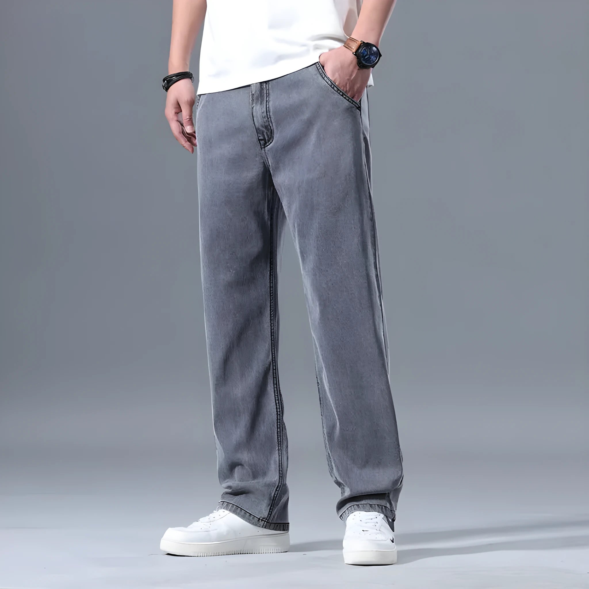 Man wearing light blue loose straight-leg lyocell jeans on a casual background.