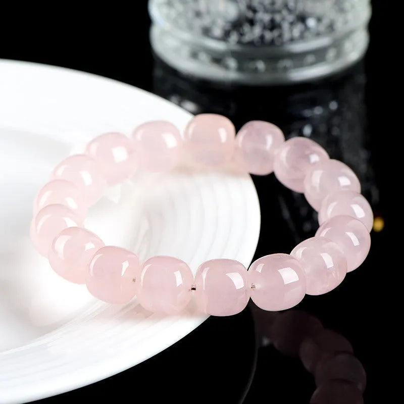 Pink crystal barrel bead bracelet with 11mm to 12mm geometric beads on natural background