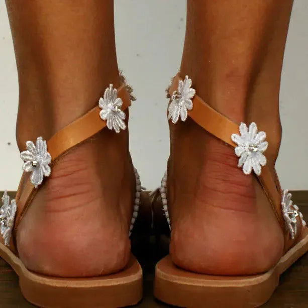 Brown women's Roman sandals with floral decoration and a flat rubber sole