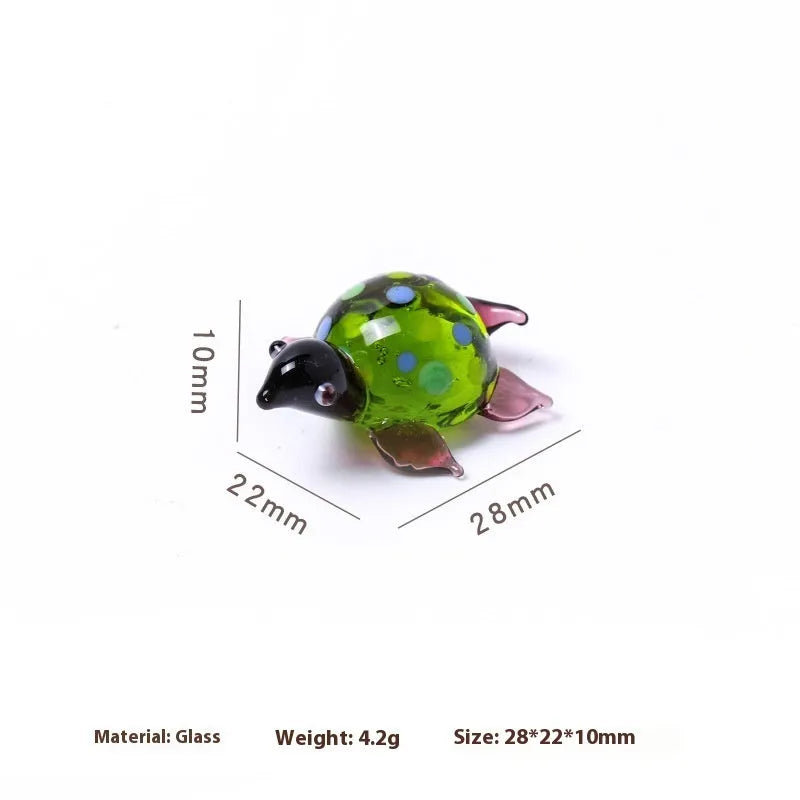 Geometric glass turtle sculpture ornament in a modern style on a wooden desktop.