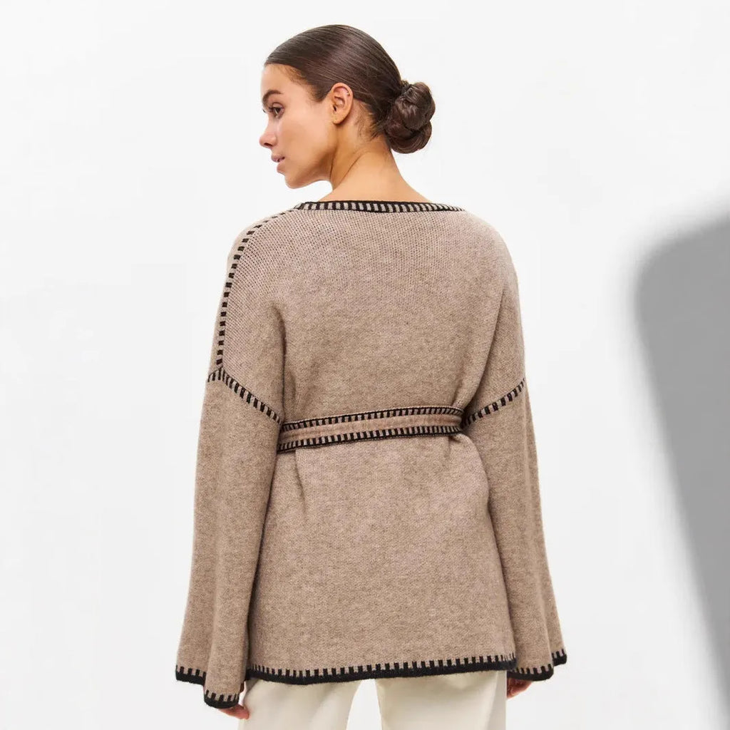 Loose fit camel coloured knitted cardigan sweater with long sleeves laid flat.