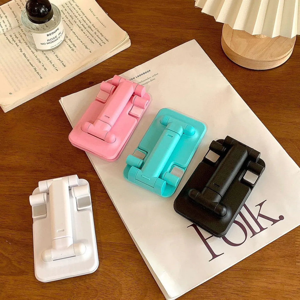 Folding plastic mobile phone stand in pearl white on a flat surface