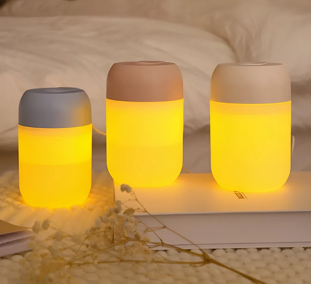 Small white cylindrical USB humidifier with aromatherapy function on a desk.
