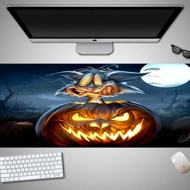 Oversized black Halloween-themed mouse pad with spooky artwork on a desk next to a gaming mouse.