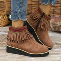 Women's black suede wedge ankle boot with side zip and tassel detail on a thick rubber platform sole.