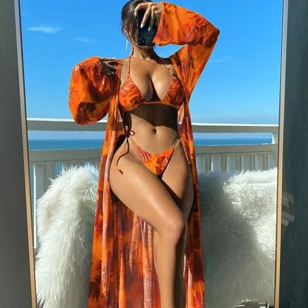 Women's long sleeve bikini set with floral pattern and matching robe on a hanger.