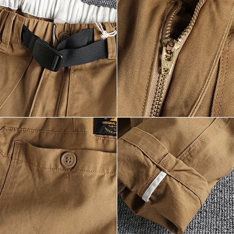 Men's khaki cotton work trousers with a black buckle belt and zip fly closure.