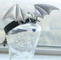 Small black patent leather dog collar with little devil wings charm and bell attached.