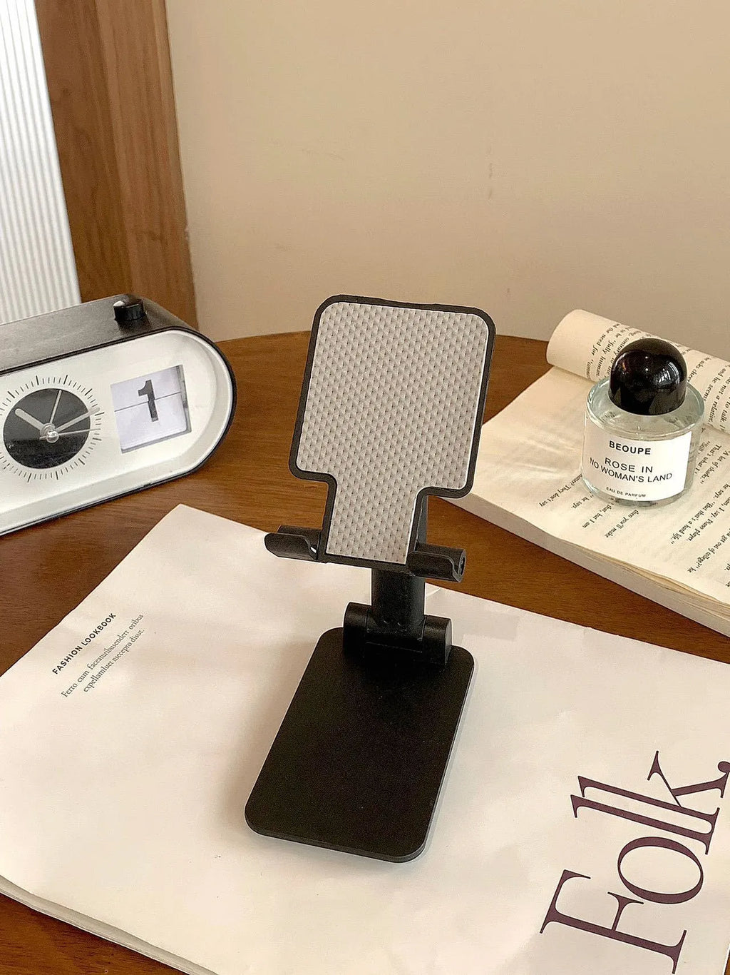 Folding plastic mobile phone stand in pearl white on a flat surface
