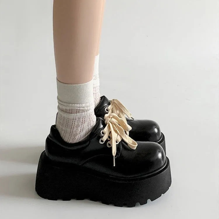 Black women's lace-up platform shoes with a chunky rubber sole and English muffin heel.