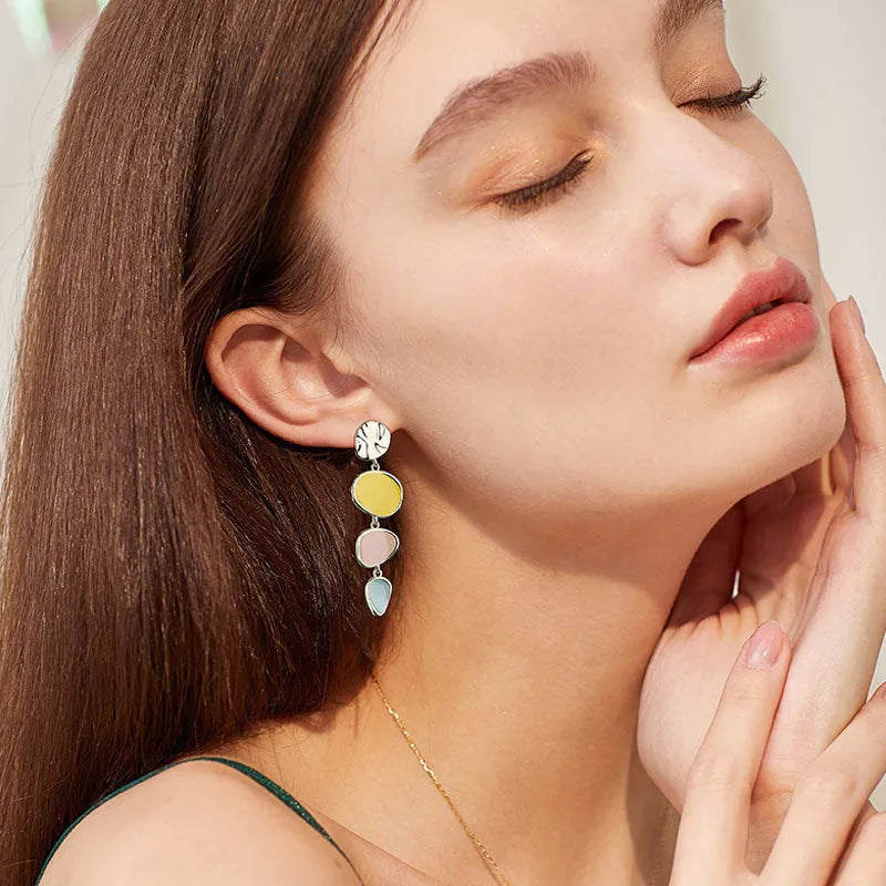 A pair of simple disc-shaped alloy earrings with a blended Morandi three-colour oil drip finish.