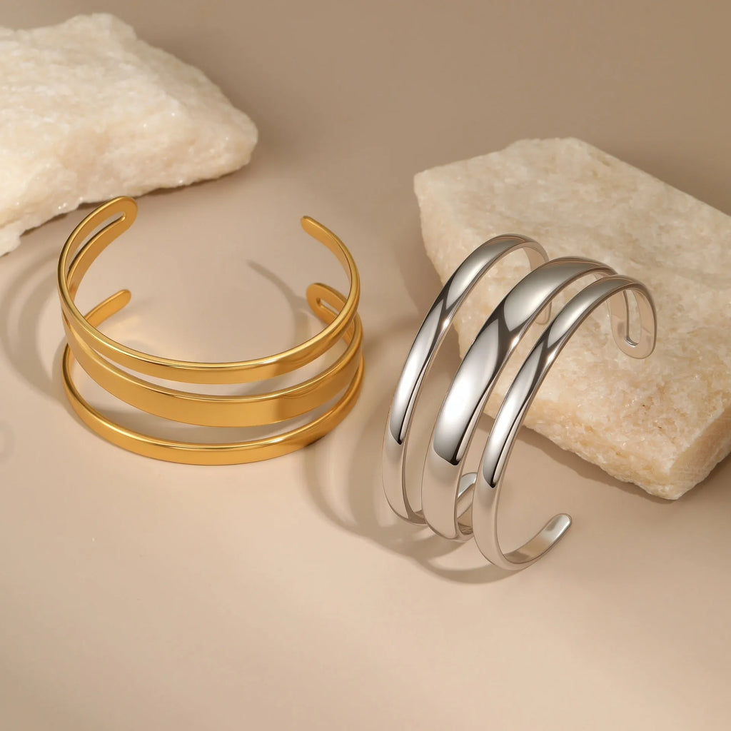 Geometric stainless steel women's bracelet with simple opening, available in gold or steel colour with linear design elements