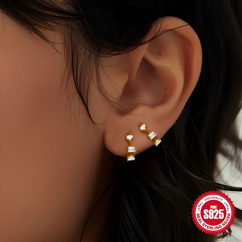 A pair of small, round, geometric stud earrings made of sterling silver with an electroplated finish.