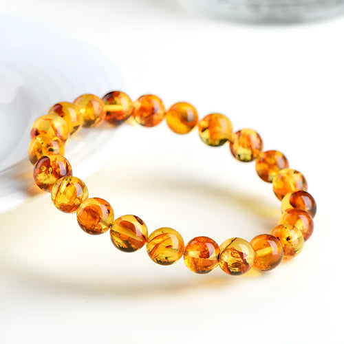 Natural yellow piebald amber bracelet with geometric beads on wrist