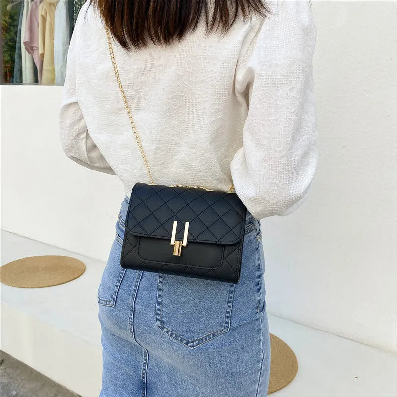 Women's diamond lattice chain crossbody bag in black with adjustable shoulder strap