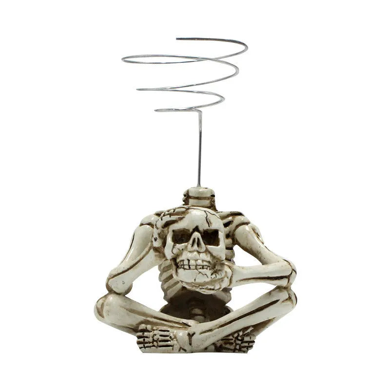 Gothic skull design resin bracket for holding soilless Tillandsia air plants on a dark background.