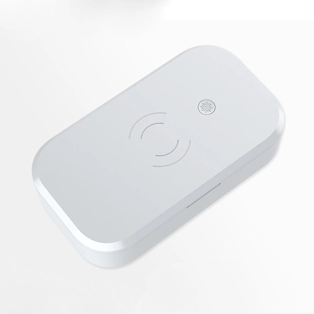 White ultraviolet disinfection box with wireless charging pad for mobile phones and nail tools.